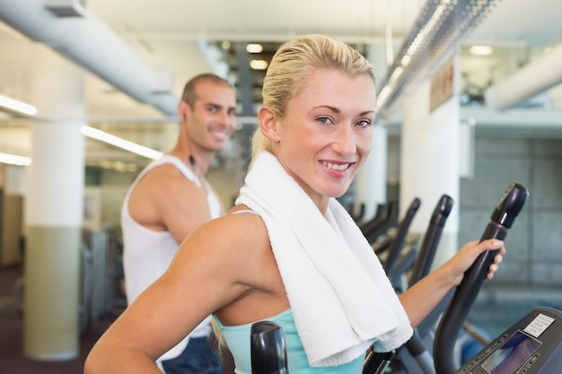 Forma joven pareja trabajando en x-entrenadores en el gimnasio