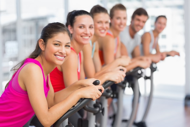 Forma jóvenes trabajando en la clase de spinning