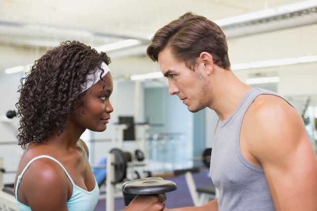 Forma pareja levantando pesas juntas