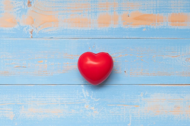 Forma roja del corazón en fondo de madera azul del color en colores pastel.
