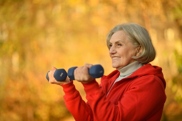 Forma Senior mujer haciendo ejercicio con pesas