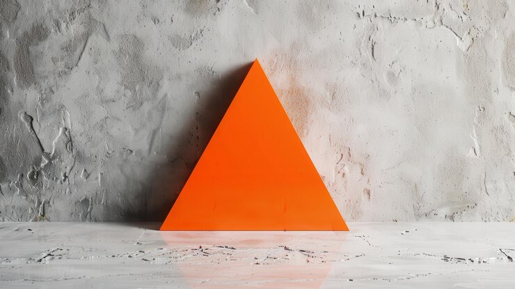 Foto forma de triángulo naranja contra la pared de hormigón