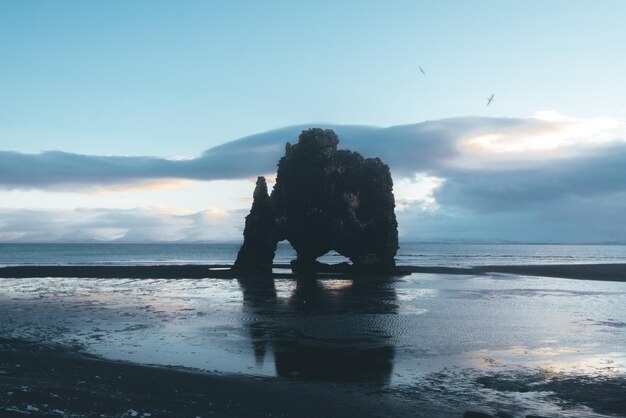 Foto formação rochosa na praia contra o céu