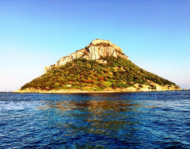 Foto formação rochosa no mar contra um céu azul claro