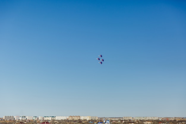 Una formación cuadrada de un grupo de cuatro aviones de combate militares rusos que vuelan alto en el cielo azul