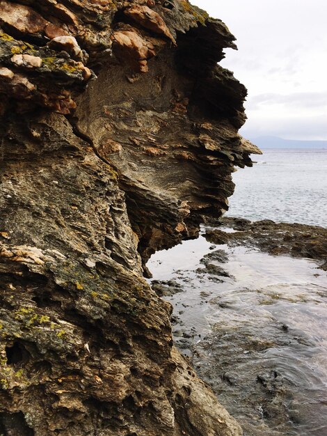 Foto formación rocosa por el mar contra el cielo