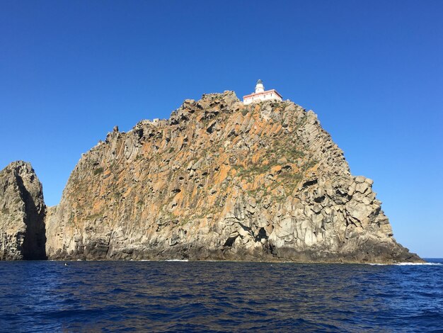 Foto formaciones rocosas en el mar contra un cielo azul claro