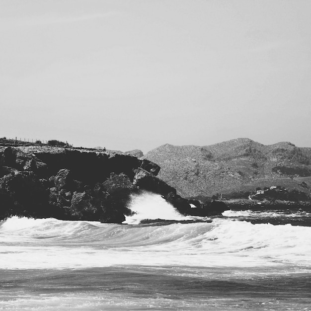 Foto formaciones rocosas en el mar con olas contra el cielo