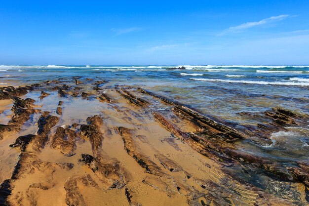 Formaciones rocosas en la playa de arena (Algarve, Costa Vicentina, Portugal).