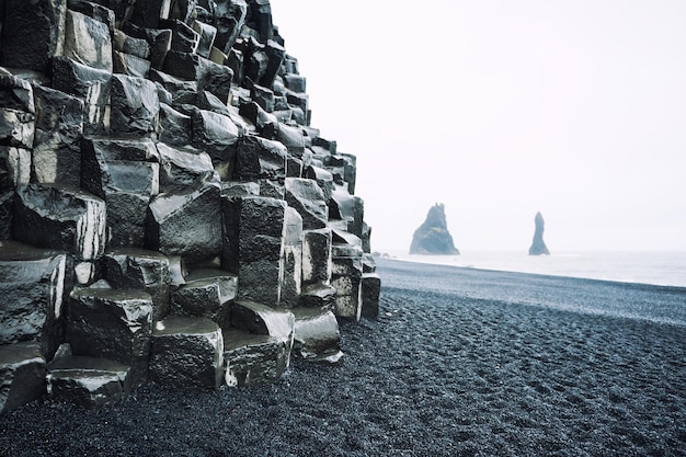 Formaciones rocosas de Reynisdrangar en la playa de Reynisfjara, costa del océano Atlántico, en el sur de Islandia