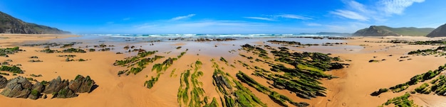 Formações rochosas na praia de areia Portugal