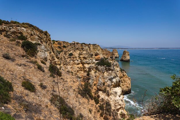 Foto formações rochosas no mar contra um céu limpo