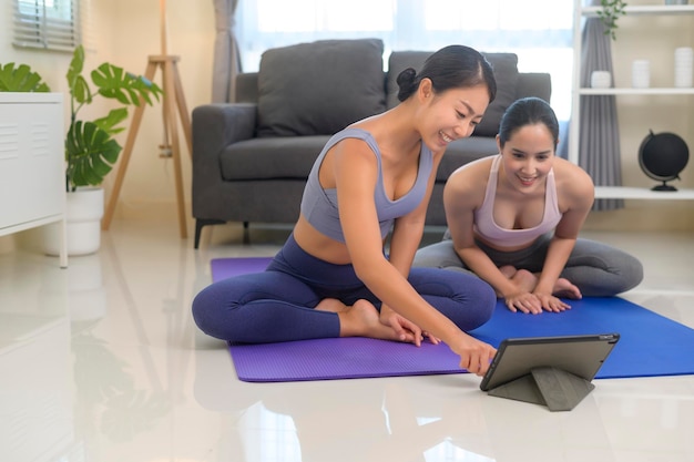 Formar jóvenes amigas practicando yoga en casa a través de clases en línea