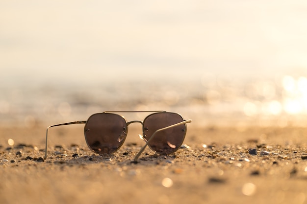 Forme óculos de sol na praia do mar sob o céu azul claro. Férias de verão relaxar fundo com cópia spac