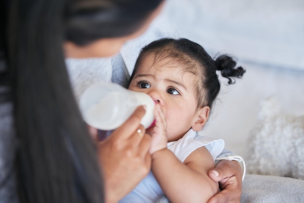 Fórmula de mamadeira para bebês e nutrição com alimentação e família saudável e crescimento com desenvolvimento na primeira infância Mãe alimenta crianças com leite em casa com saúde e bem-estar