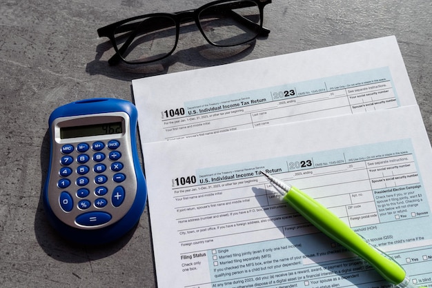 Formulário 1040 de declaração de imposto sobre o rendimento individual em branco com calculadora de óculos de caneta