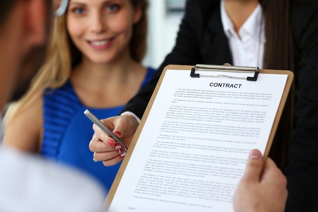 Foto formulario de contrato de oferta de brazo femenino en almohadilla