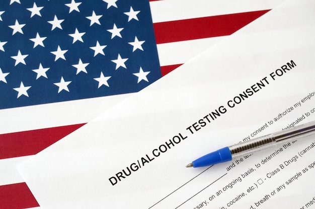 Formulário de consentimento para testes de drogas e álcool com caneta azul na bandeira dos Estados Unidos