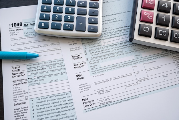 Formulário de imposto 1040 com caneta e calculadora na mesa do escritório