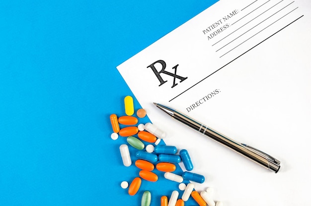 Formulário de prescrição com pílulas e caneta com vista superior azul Conceito médico