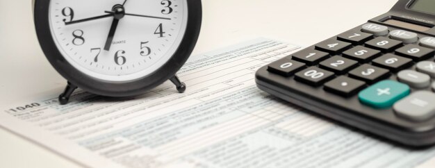 Formulario de impuestos con lápiz de reloj y calculadora sobre fondo blanco Concepto de negocio