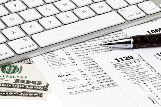 Foto los formularios de impuestos con dinero y la pluma. concepto del día de impuestos.