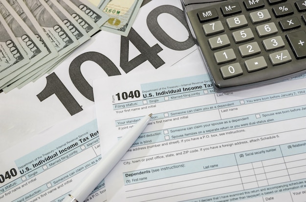 Formularios de impuestos con dólares y calculadora