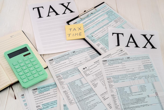 Los formularios de impuestos estadounidenses se colocan en una mesa junto a la cual hay un cuaderno con un bolígrafo