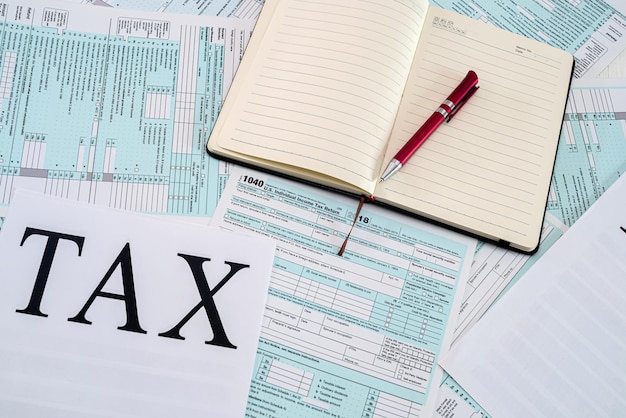 Los formularios de impuestos estadounidenses se colocan en una mesa junto a la cual hay un cuaderno con bolígrafo