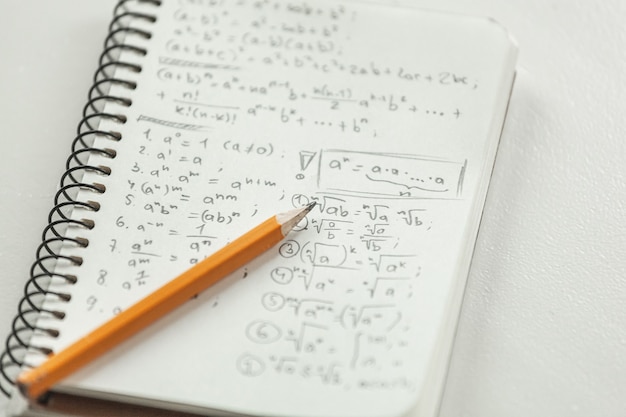 Las fórmulas matemáticas están escritas a lápiz sobre papel, problemas matemáticos