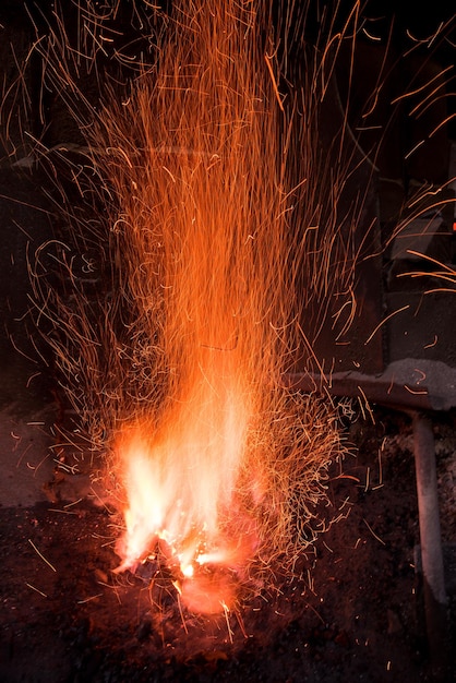 Fornalha de ferreiro tradicional com fogo ardente Fogo ardente na fornalha na forja, oficina. Conceito de equipamento de ferreiro