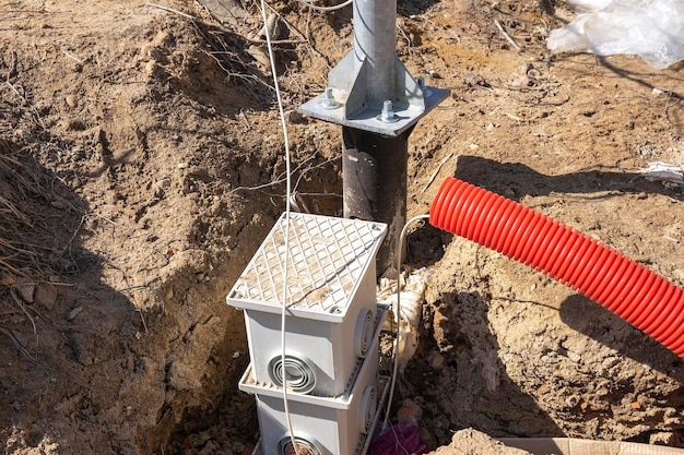Fornecimento de um cabo elétrico a um poste de iluminação colocação de uma caixa de junção de cabos elétricos fiação subterrânea do cabo de alimentação