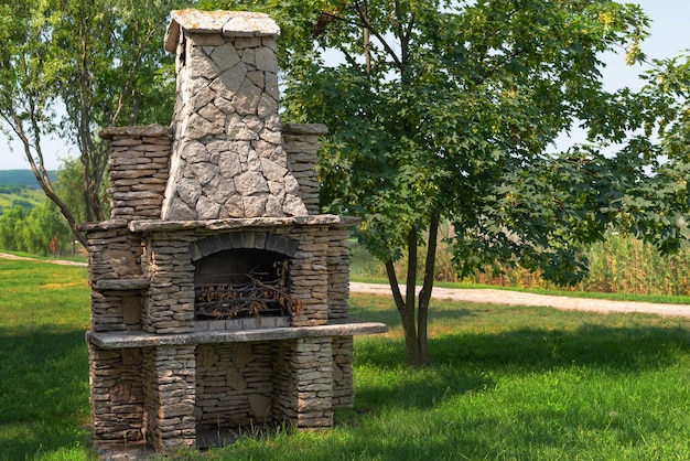 Forno de jardim de pedra para churrasco ou churrasco está em um quintal