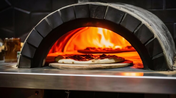 Foto forno de madeira sendo preparado sobre fogo alto para assar as pizzas de uma pizzeria
