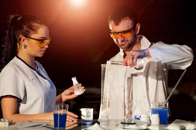 Forscher Männer und Frauen arbeiten mit Laborglaswaren der pharmazeutischen Industrie im Wissenschaftslaborraum Schwarzer Hintergrund