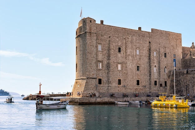 Fortaleza de Dubrovnik e barcos com pessoas no porto do Mar Adriático, Croácia