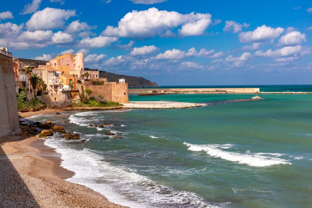 Fortaleza medieval ensolarada em Cala Marina, porto na cidade costeira de Castellammare del Golfo e Praia Cala Petrolo, Sicília, Itália