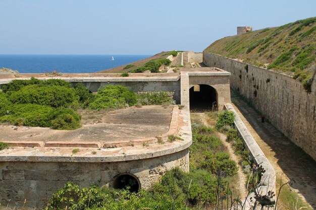 Fortaleza de la Mola invadida por la naturaleza con el mar