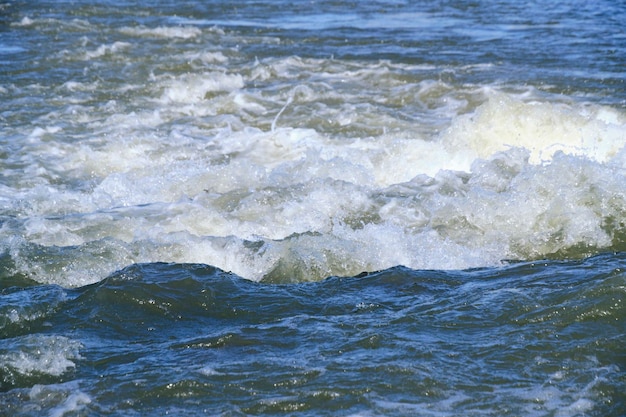 Forte fluxo de água com salpicos e espuma entre corredeiras