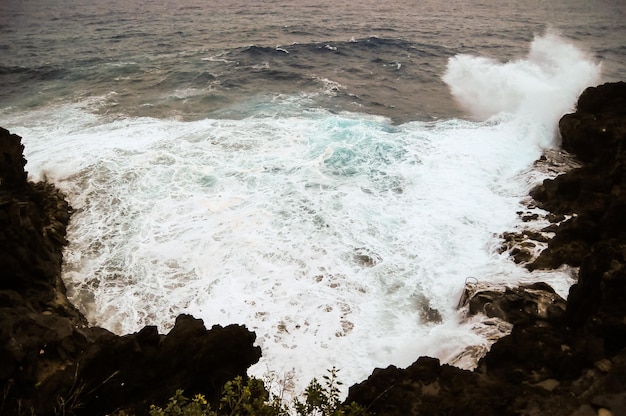 Fortes ondas quebrando na costa vulcânica em Tenerife Ilhas Canárias