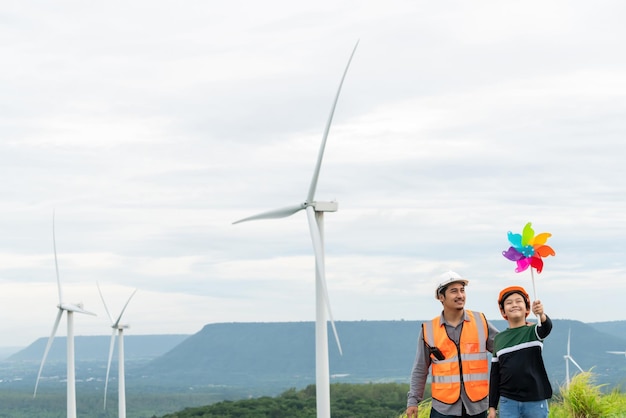 Fortschrittlicher Ingenieur mit seinem Sohn, der Windmühlenspielzeug im Berg hält