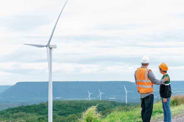 Fortschrittlicher Ingenieur mit seinem Sohn im Windpark auf dem Berg