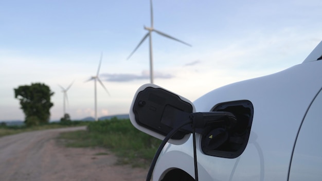 Fortschrittliches zukünftiges Energieinfrastrukturkonzept, bei dem Elektrofahrzeuge an einer Ladestation aufgeladen werden, die mit grüner und erneuerbarer Energie aus einer Windkraftanlage betrieben wird, um die Umwelt zu schonen