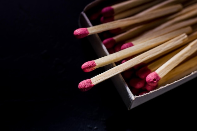 Fósforos de madera roja sobre un fondo gris claro Fósforos con macro de cabezas rojas brillantes