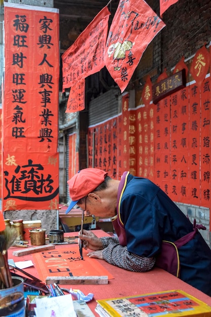 Foshan Provinz Guangdong China 14. JAN 2022 Menschen schreiben Couplets mit Grüßen zum Frühlingsfest Vorbereitung auf die chinesische Neujahrsfeier in der Kuaizi Straße in Foshan