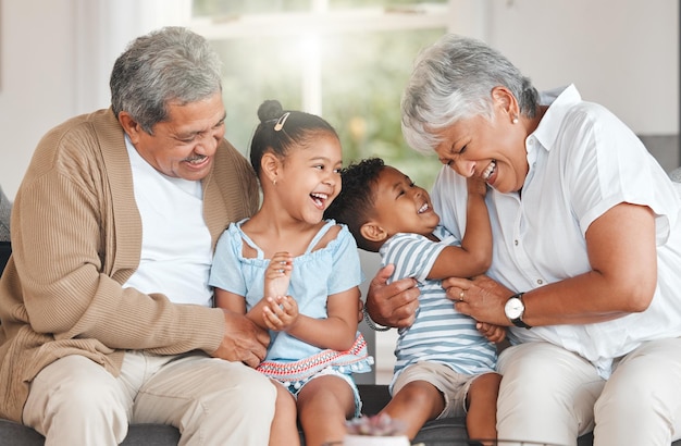 Foto de abuelos uniéndose a sus nietos en un sofá en casa