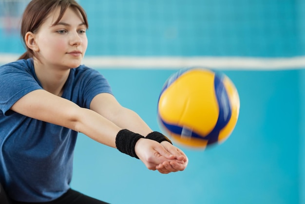 Foto en acción de una niña jugando voleibol Una joven dominando las habilidades de voleibol en la cancha de voleibol