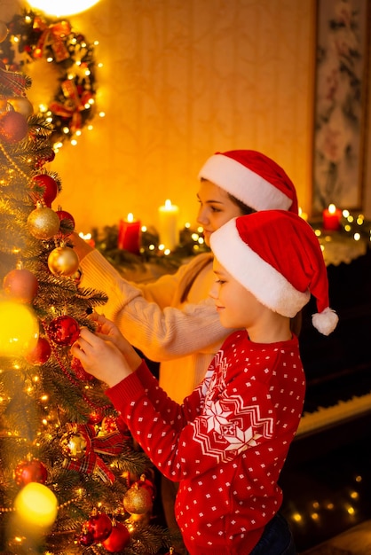 Foto acogedora atmosférica de niños decorando un hermoso árbol de navidad en casa