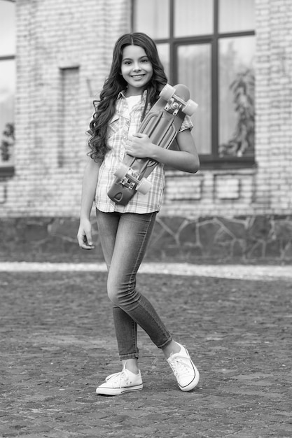 foto de una adolescente positiva haciendo skateboard Skateboarding de una adolescente al aire libre