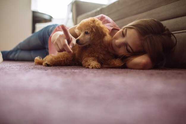 Foto de un adolescente tirado en el suelo con un cachorro.